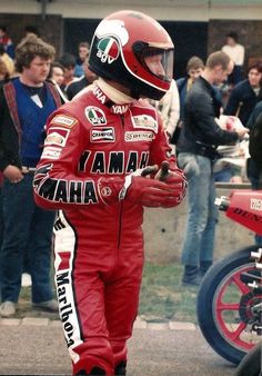 a man in a red racing suit and helmet