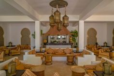 a living room filled with lots of couches and chairs under a chandelier