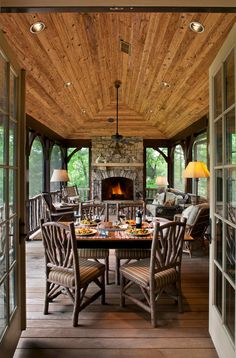 an outdoor dining area with wood flooring and wooden ceiling, along with glass doors leading to the outside deck