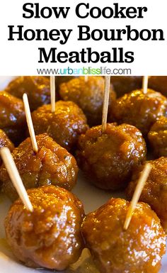 slow cooker honey bourbon meatballs with toothpicks in them on a white plate