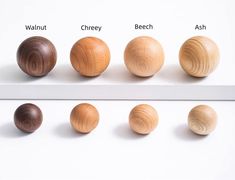 four different types of wood balls on a white surface with the words walnut, cherry, beech, ash and walnut