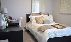 a bed sitting in a bedroom next to a table with a tray on top of it