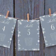 two calendars hanging on clothes pins with snowflakes and numbers attached to them