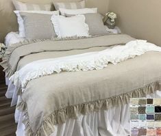 a bed with white ruffles and pillows in a room next to a wall