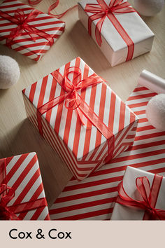 red and white boxes wrapped in striped paper with bows on the top one has a pom pom