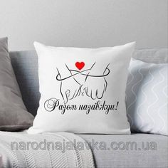 a white pillow sitting on top of a couch next to two pillows and a red heart