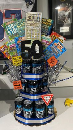 a birthday cake made to look like a tower of beer cans with the number 50 on top