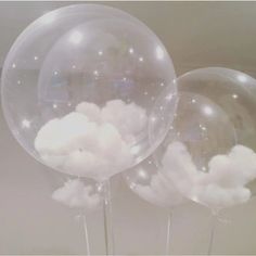 three clear balloons with clouds floating in them