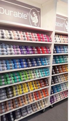 there are many different colors of yarn on the shelves