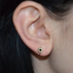 a woman's ear is shown with a small flower in the middle of it