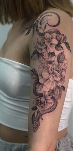 a woman with a snake and flowers tattoo on her arm