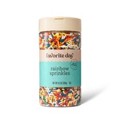 a jar filled with rainbow sprinkles on top of a white surface