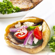 an open pita sandwich with meat and vegetables