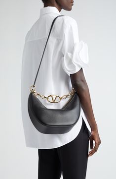 A gleaming chain centered with a VLOGO insignia spans the top of this hobo crafted from calfskin leather in a perfectly slouchy silhouette. Top zip closure Shoulder strap Leather lining Leather Made in Italy Designer Handbags Crossbody Bag Valentino, Chanel Hobo Bag, Valentino Bag, Bag With Chain, Chain Top, Leather Handbags Women, Handbags Women, The Saint, Leather Hobo Bag