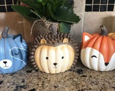 three painted pumpkins sitting on top of a counter