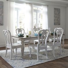 a dining room table and chairs in front of a window