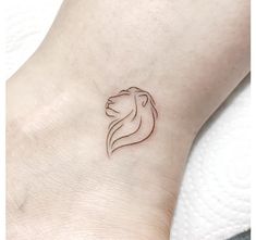 a woman's foot with a small lion tattoo on her left ankle and side