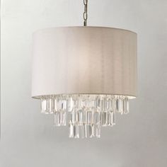 a chandelier hanging from a ceiling with a white shade on it's side