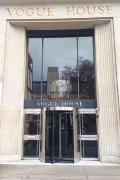 the front entrance to a building with large glass windows and an inscription that reads voque house