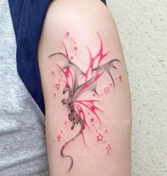 a woman's arm with red ink on it and a tattoo design in the shape of a dragon