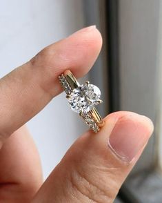 a person holding an engagement ring in their hand