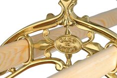 a close up view of a gold and wood bow with an emblem on the side