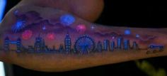 a man's arm with fireworks and buildings on it