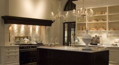 an elegant kitchen with chandelier and marble counter tops