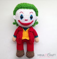 a crocheted clown doll sitting on top of a white table