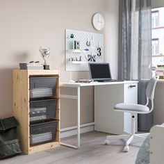 a laptop computer sitting on top of a white desk next to a chair and window