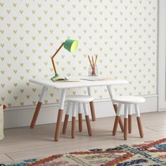 two children's table and chairs in front of a wall with hearts on it