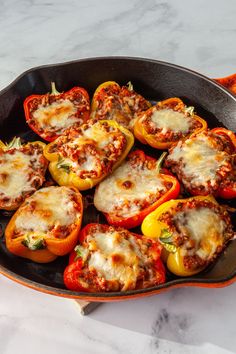 stuffed bell peppers in a cast iron skillet on a marble counter top, ready to be eaten