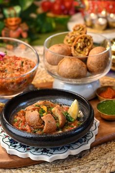 some food is sitting on a table with other foods in bowls and plates around it