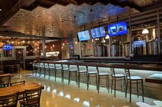 an empty bar with several televisions on the wall