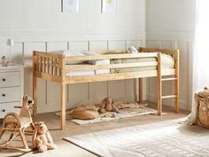 a wooden bunk bed sitting on top of a hard wood floor next to a baby crib