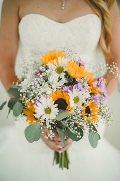 a bridal holding a bouquet of sunflowers and baby's breath flowers