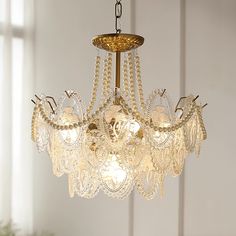 a chandelier with pearls hanging from it's center and two lights on each side