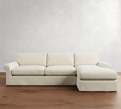 a white couch sitting on top of a hard wood floor