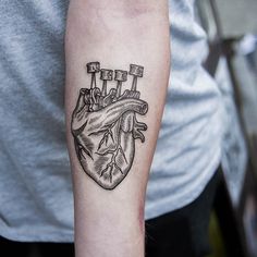 a black and white heart tattoo on the arm