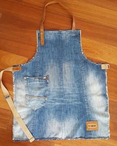 an apron made out of old jeans is on the floor with a leather strap around it