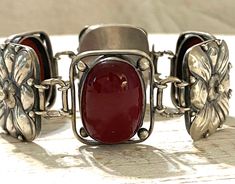 "A rare bracelet by Jane Carson Barron and Frances Barnum Smith, Arts and Crafts, Cleveland, OH. The two women had a studio in Cleveland for a short period together from 1902-1905. The bracelet features oval red stones that I believe to be petrified wood. The bracelet measures 7\" x 1\". Good condition, some tarnish and patina. Circa 1902-1905 33.95g" Victorian Polished Bracelets For Formal Occasions, Victorian Polished Finish Bracelet Gift, Antique Oval Hallmarked Bracelet, Victorian Bracelets With Polished Finish, Victorian Bracelets With Polished Finish As Gift, Victorian Bracelet With Polished Finish As Gift, Handmade Oval Sterling Silver Bracelet In Vintage Style, Vintage Sterling Silver Cabochon Bracelets, Vintage Sterling Silver Bracelets With Cabochon