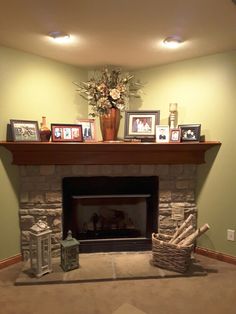 a living room with a fire place and pictures on the mantle