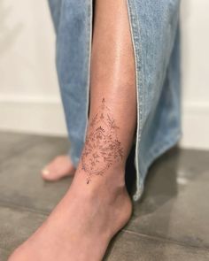 a woman's leg with a tattoo on her left arm and the bottom part of her legs