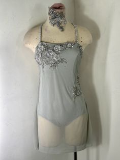 a mannequin is wearing a gray dress with silver sequins on it