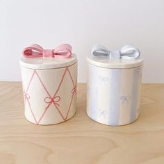 two small boxes with bows on them sitting on a table next to each other,