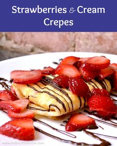 strawberries and cream crepes on a plate with chocolate drizzled