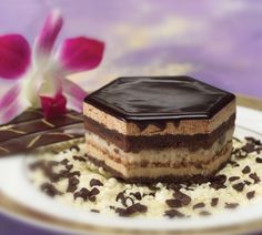 a piece of cake sitting on top of a white plate next to a pink flower