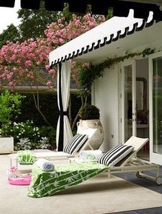 two women sitting on lawn chairs under an awning