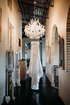 a white wedding dress hanging from a chandelier