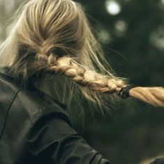 a woman with long blonde hair is using an electric toothbrush to brush her hair